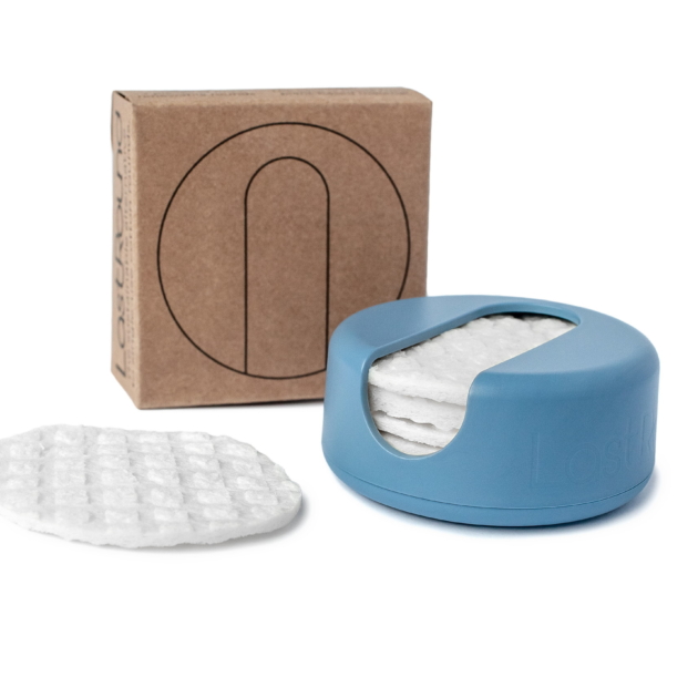 Tuote kuvassa. Vanulappu, sen muovinen säilytysrasia jossa yhteensä 7 kappaletta vanulappuja sekä pahvinen kotelo. Pastellinsininen kotelo.